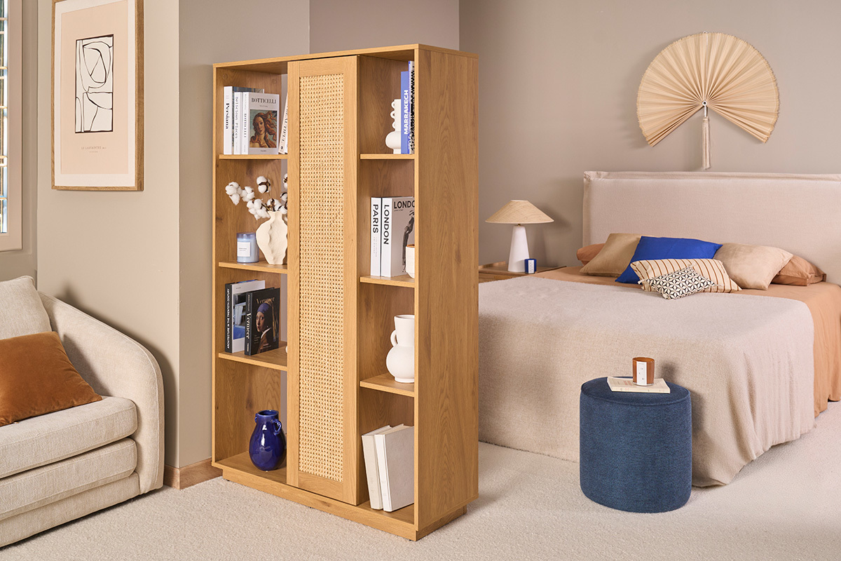 Biblioth�que s�paratrice en bois clair avec cannage rotin, vue de trois quarts dans un int�rieur moderne.