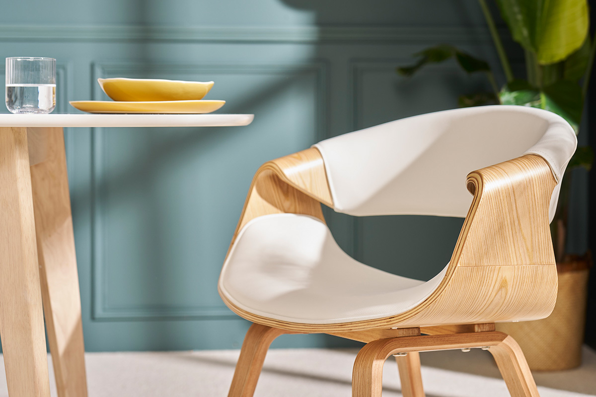Chaise design ARAMIS blanche avec accoudoirs, vue de c�t�, � c�t� d'une table.