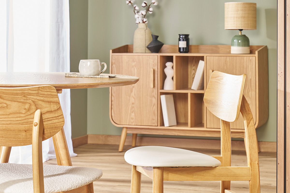 Chaises scandinaves en bois clair et blanc autour d'une table, vue d'angle dans un int�rieur.