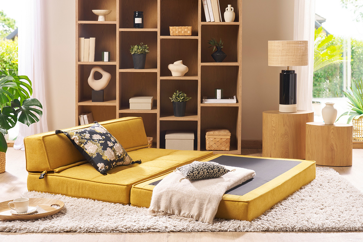 Chauffeuse convertible KATY en tissu velours jaune moutarde, vue de 3/4 avec coussin d�coratif.