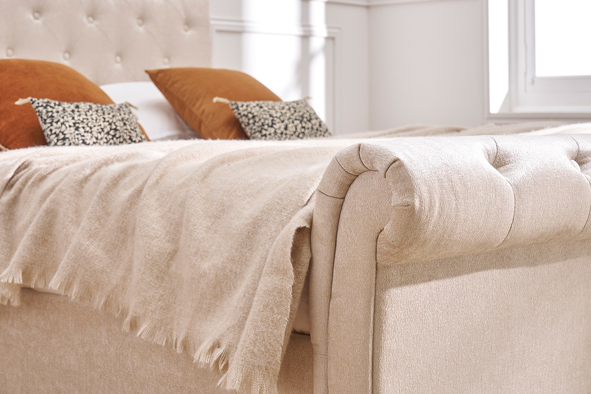 D�tail du lit 2 places 160x200 cm en velours beige avec t�te capitonn�e, vue de pr�s.