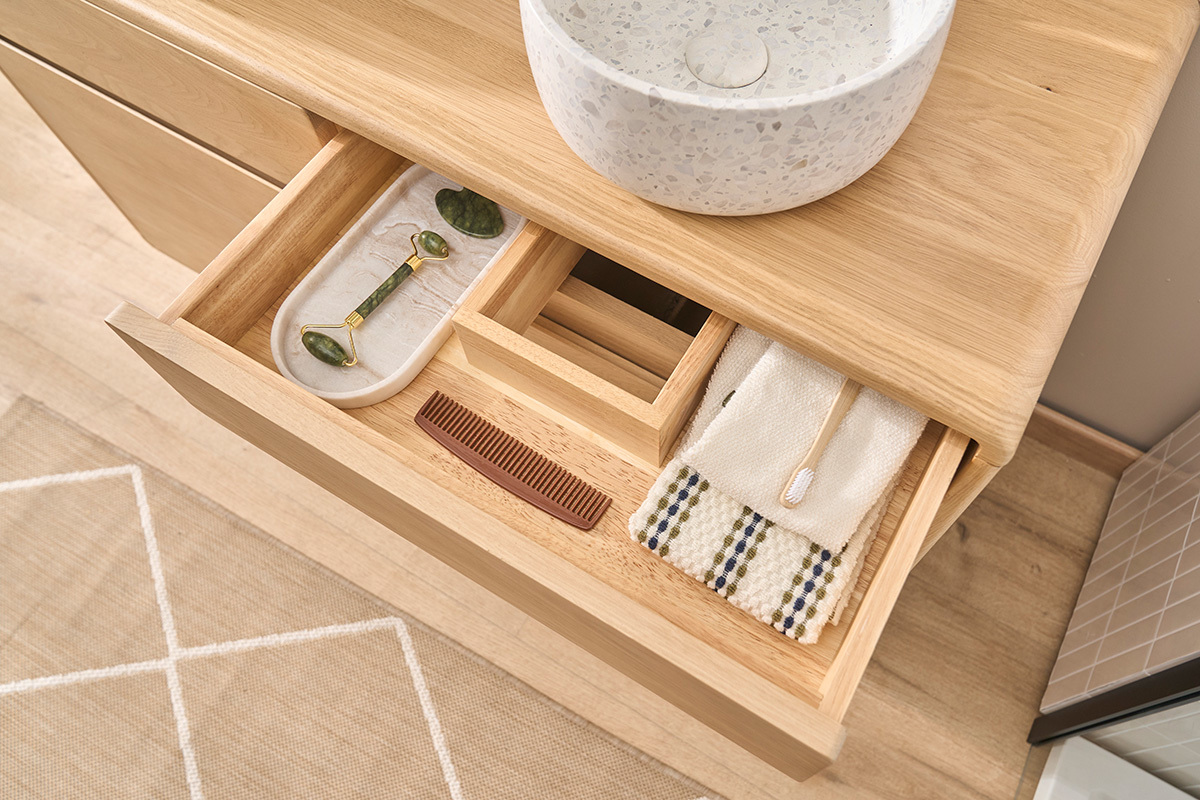 Tiroir ouvert du meuble de salle de bain ESTEBAN en bois ch�ne massif, avec accessoires de bain.