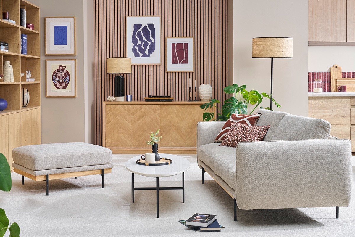 Pouf repose pieds en tissu beige dans un salon moderne, angle de c�t�.