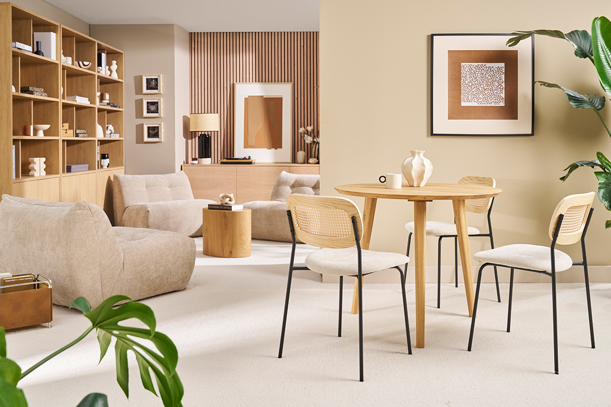 Table � manger ronde en bois clair avec quatre chaises, vue d'ensemble d'un salon moderne.